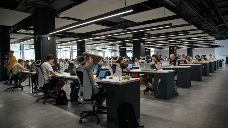 A large open-plan office with rows of people working at desks